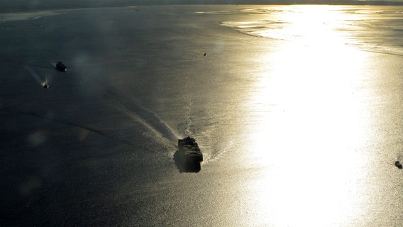 Luftaufnahme eines Containerschiffs im Gegenlicht der Abendsonne bei Einfahrt in die Elbe. © NDR Foto: Sven Teller