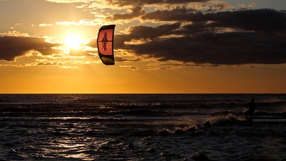 Kitesurfer vor untergehender Sonne in  St. Peter Ording. © NDR Foto: Jochen Sass