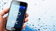 Das Display eines Smartphones zeigt ein Wetterapp-Icon © Fotolia Foto: pab_map