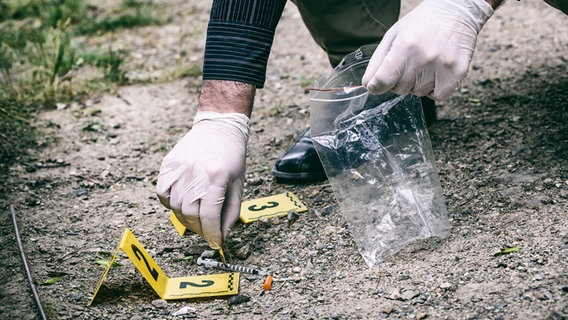 Ein Mann sichert eine Spritze in eine Plastiktüte. © fotolia Foto: milankubicka