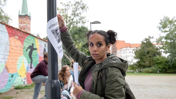 Meryems (Kristin Alia Hunold) Freund Nick wurde entführt. Weil die Polizei ihr anfangs keinen Glauben schenkt, macht sie sich selber auf die Suche nach ihm und hängt Vermisstenanzeigen auf. © ARD/Thorsten Jander 