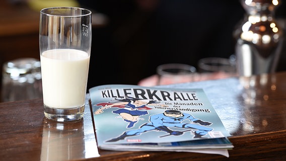 Neues aus Büttenwarder - Dreharbeiten 2015: Ein Glas Milch und ein Killerkralleheft liegen auf dem Tresen im Dorfkrug. © NDR/Nicolas Maack Foto: Nico Maack