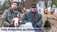 Festliche Grußkarte mit der Aufschrift: "Frohe Weihnachten aus Büttenwarder" - Adsche, Brakelmann und eine Ziege mit Weihnachtsmütze vor einem Misthaufen, auf dem Hühner laufen. © NDR/Nicolas Maack 