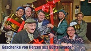 Festliche Grußkarte - Heinzi, Shorty, Griem, Krischan, Kuno, Seute und Adsche halten Geschenkpakete in die Höhe. Aufschrift: "Geschenke vom Herzen aus Büttenwarder". © NDR/Nicolas Maack Foto: -