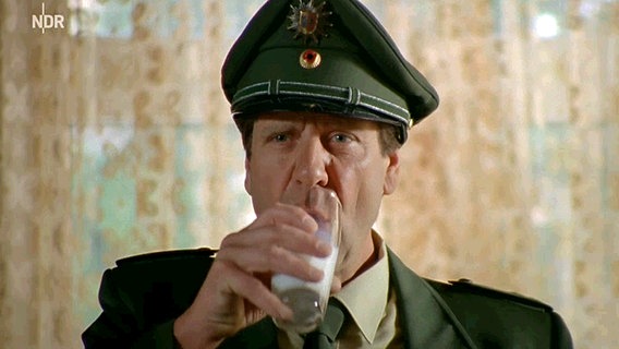 Neues aus Büttenwarder: Polizist Peter trinkt ein Glas Milch. © NDR 