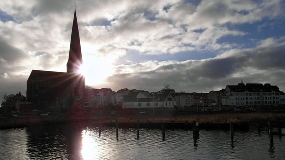 Die Sonne guckt hinter dem Turm der Petrikirche in Rostock hervor. © NDR Foto: Helmut Kuzina aus Wismar