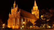 "Jetzt, wo die Tage kürzer werden, kann man sogar noch zu den Geschäftszeiten die Konzertkirche in Neubrandenburg im nächtlichen Glanz bewundern. Das Bild zeigt die Neubrandenburger Marienkirche (Konzertkirche) im goldenen Scheinwerferlicht." kommentiert Frank Meinel aus Neubrandenburg zu diesem Foto. © NDR Foto: Frank Meinel aus Neubrandenburg