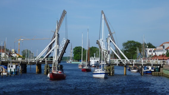 Hochgeklappte Brücke, durch die einige Boote unterwegs sind © NDR Foto: Marianne Schultz aus Stralsund