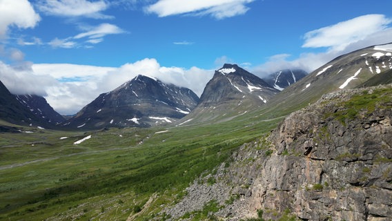 Das Gebirge im Norden Lapplands. Hier liegt der Kebnekaise, Schwedens höchster Berg, der sich rechts in den Wolken versteckt. Neben ihm der ikonografische Tuolpagorni, der an einen Vulkan erinnert. © NDR 