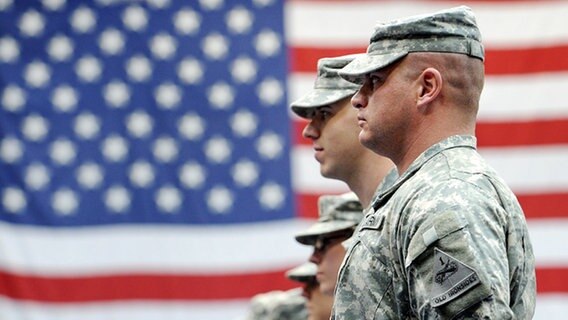 US-Soldaten stehen vor der amerikanischen Nationalflagge © dpa Foto: Frank May