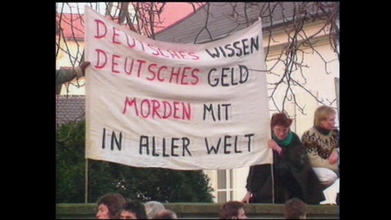 Demonstrierende halten ein Banner mit der Aufschrift "Deutsches Wissen, Deutsches Geld, morden mit in aller Welt" (Archivbild).  
