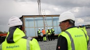 Arbeiter mit Warnwesten bei Aufbauarbeiten auf dem Gelände der geplanten Batteriefabrik in Heide, Schleswig-Hosltein (Archiv) © picture alliance/dpa Foto: Christian Charisius