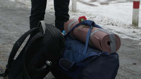 Die Tasche einer Selbststellerin mit Isomatte und Blume, bevor sie sich in Polizeigewahrsam begibt. © NDR/Sebastian Heidelberger Foto: Sebastian Heidelberger