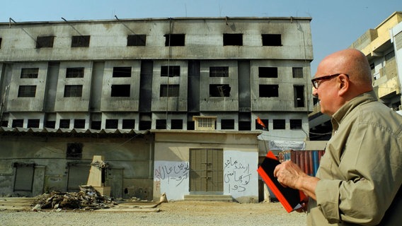 Christoph Lütgert vor der ausgebrannten Textilfabrik in Karachi.  