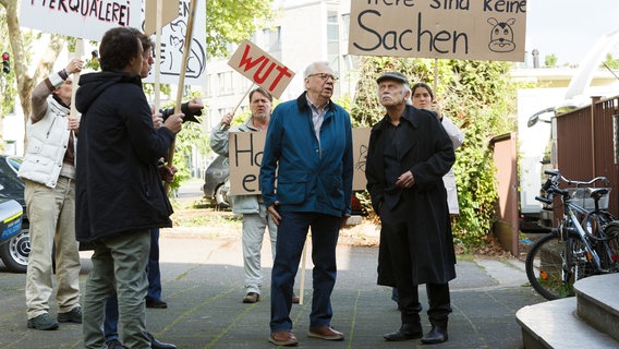 Günter (Peter Lerchbaumer, 2.v.r.) und Edwin (Tilo Prückner, r.) geraten auf ihrem Weg ins Altenheim, in eine Tierschutzdemo (mit Komparsen). © NDR/ARD/Kai Schulz 