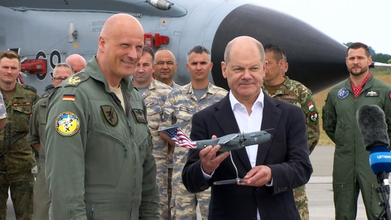 Olaf Scholz bei einem Besuch in Jagel bei der Überreichung eines Geschenks. © NDR Foto: NDR