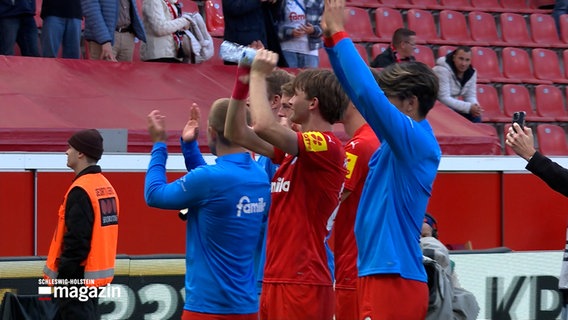 Spieler von Holstein Kiel winken den Fans nach einem Spiel zu. © NDR 