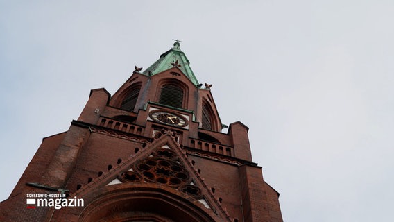 Der Turm der Pauluskirche in Kiel ragt in den grauen Himmel. © NDR 