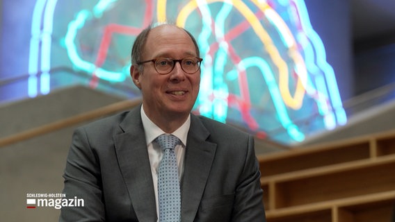 Prof. Helge Braun künftiger Präsident der Universität zu Lübeck sitzt in einem Foyer der Lübecker Uni. © NDR 