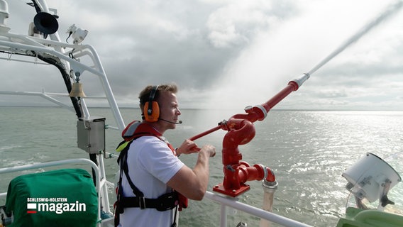 Ein Crewmitglied steht an einer Feuerlöschanlage auf einem Schiff der Seenotrettung © NDR Foto: NDR