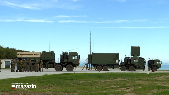 Zwei Lkw der Bundeswehr stehen mit unterschiedlichen Aufbauten auf einem Platz. © NDR Foto: NDR Screenshots