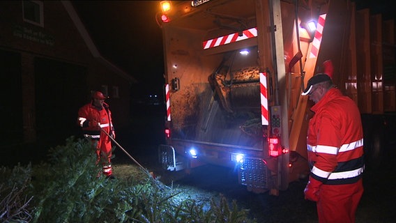 Zwei Männer verladen alte Weihnachtsbäume in ein Müllfahrzeug © NDR Foto: Screenshot: Schleswig-Holstein Magazin Sendung in der KW 2