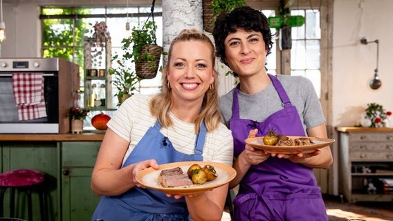 Theresa & Zora mit ihrem zubereiteten Rumpsteak mit Pfeffersoße in den Händen. © NDR/Claudia Timmann 