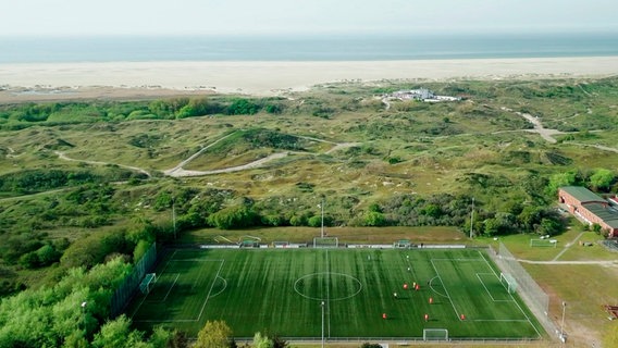 Inselidylle: Der Platz vom TuS Borkum liegt unmittelbar hinter den Dünen. © NDR 