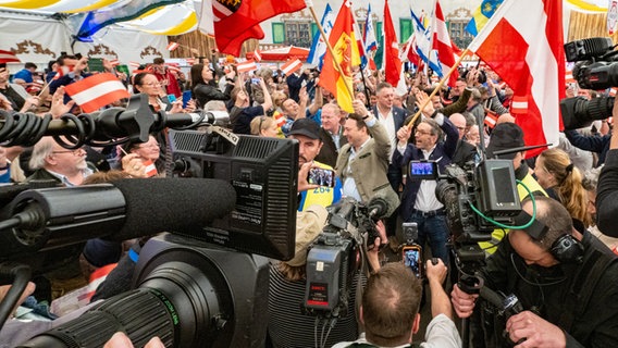 Eine Wahlkampfveranstaltung der FPÖ in einem Festzelt: fahnenschwenkend in der Mitte Herbert Kickl, alle Kameras auf ihn gerichtet © picture alliance / WERNER KERSCHBAUMMAYR / APA / picturedesk.com Foto: Werner Kerschbaummayr