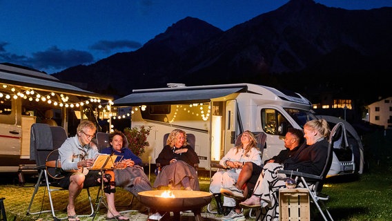 Ein aufregender zweiter Camping-Tag geht zu Ende. (V.l.n.r.) Ingolf Lück, Oliver Mommsen, Bettina Tietjen, Lola Weippert, Cossu und Gisa Flake lassen ihn entspannt bei einem musikalischen Lagerfeuer ausklingen. © NDR/Daniel Wolcke/beckground tv 