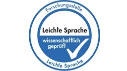 Ein blaues kreisförmiges Siegel auf weißem Hintergrund. Im Siegel steht: Leichte Sprache wissenschaftlich geprüft. © Universität Hildesheim 