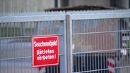 Ein Hinweisschild hängt an einem geschlossenen Tor: "Seuchenobjakt - Betreten verboten!" © Screenshot 