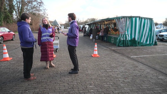 Mitglieder der Partei Volt werben für ihre Partei auf einem Markt. © Screenshot 