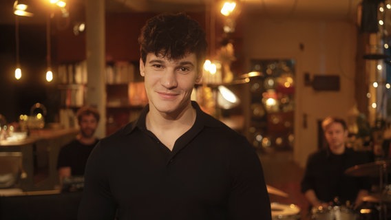 Wincent Weiss steht in einem weihnachtlich beleuchteten Zimmer. © NDR/Bildergarten 