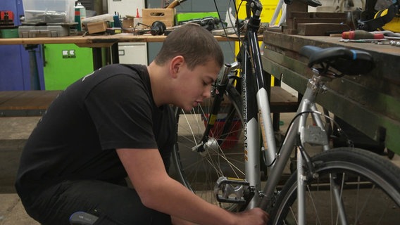 Eine Junge schraubt in einer Jugendwerkstatt an einem Fahrrad. © NDR Foto: Christina Harland