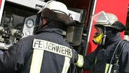 Feuerwehrmänner im Einsatz am Feuerwehrwagen. © Colourbox 