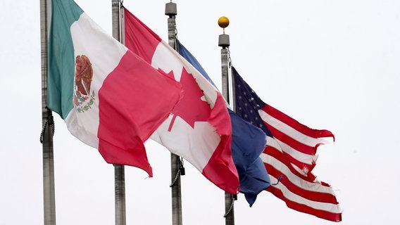 USA, Detroit: Die Flaggen von Mexiko, Kanada und den USA sind in der Nähe der Ambassador Bridge in Detroit, Michigan zu sehen. © Paul Sancya/AP/dpa 