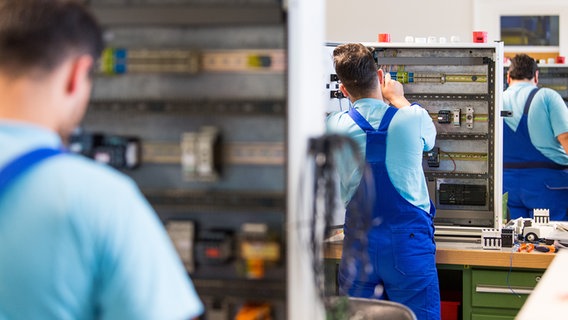 Drei junge Flüchtlinge arbeiten im Ausbildungszentrum der Siemens Professional Education an der Verdrahtung eines Schaltschranks. © picture alliance / Monika Skolimowska/dpa-Zentralbild/dpa | Monika Skolimowska Foto: Monika Skolimowska