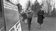 Der damalige Bundesfinanzminister Helmut Schmidt (SPD) mit seiner Ehefrau Hannelore "Loki" Schmidt an seiner Seite auf dem Weg zum Wahllokal im Hamburger Stadtteil Langenhorn am 03.03.1974, vorne links ein Wahlplakat der SPD. © picture-alliance/ dpa Foto: Werner Baum