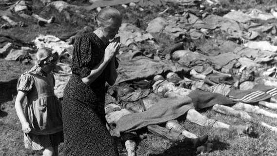 Eine Mutter mit ihrer Tochter wird gezwungen, sich die Leichen von KZ-Häftlingen, die bei einem sogenannten Todesmarsch in den letzten Kriegstagen von der SS erschossenen wurden, anzuschauen. © National Archives and Records Administration, College Park 