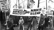 Aus Hamburg kommende Demonstranten auf ihrem Marsch am 18. April 1960: Demonstranten in Regenkleidung halten Plakate wie 'Atomare Aufrüstung bedeutet Krieg und Elend'. © picture-alliance / dpa Foto: Marek