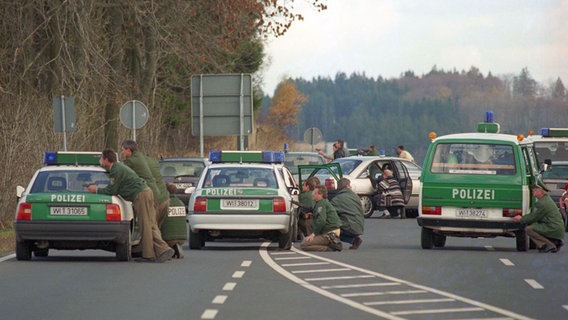 Polizisten stehen und hocken schußbereit hinter ihren Fahrzeugen am Eingangsbereich der Feriensiedlung Heisterberg. © picture alliance / Frank Kleefeldt Foto: Frank Kleefeldt