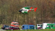 Ein Hubschrauber der Polizei kreist über Polizeifahrzeugen und einem Rettungswagen in der Luft. © picture alliance / Frank Kleefeldt Foto: Frank Kleefeldt