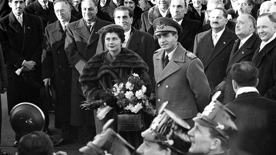 Der Schah von Persien, Reza Pahlevi, und Kaiserin Soraya, werden von Tausenden Menschen in Hamburg willkommen geheißen, nachdem sie am 23. Februar 1955 auf dem Flughafen der Hansestadt angekommen sind. © picture alliance / ASSOCIATED PRESS Foto: BRUEGGEMANN