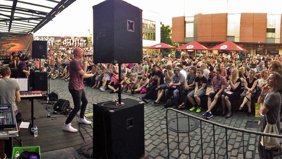 Zuschauer sitzen auf dem Lattenplatz vor dem Musikclub Knust in Hamburg bei den Knust Accoustics. © Knust Hamburg 