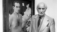 Maler Christian Schad im Jahr 1980 bei einer Ausstellung in der Staatlichen Kunsthalle Berlin vor seinem Gemälde "Selbstbildnis" von 1927 © picture-alliance / akg-images / Binder Foto: Binder