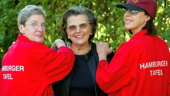 Mit zwei Mitarbeiterinnen der "Hamburger Tafel" steht Gründerin Annemarie Dose (M) am 15.07.2002 auf dem Gelände der Stiftung in Hamburg. © picture-alliance / dpa/dpaweb Foto: Sören Stache