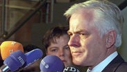 Umgeben von Mikrofonen beantwortet der ehemalige niedersächsische Ministerpräsident Gerhard Glogowski (SPD) am 5.4.2000 in Hannover vor Beginn seiner Vernehmung vor dem Untersuchungsausschusses des Landtages die Fragen der Medienvertreter. © picture-alliance / dpa Foto: Rainer Jensen