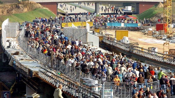 Fußgänger und Radfahrer sind am 03.10.2004 auf dem fast fertigen Abschnitt der Ostseeautobahn A20, wie hier auf der Wakenitzbrücke an der Landesgrenze von Mecklenburg-Vorpommern nach Schleswig-Holstein, unterwegs. © picture alliance Foto: Jens Büttner