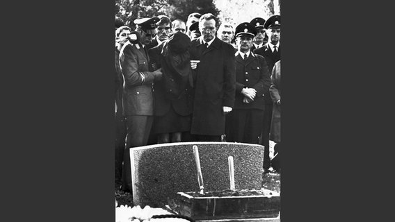 Die Witwe des von der RAF erschossenen Polizisten Norbert Schmid wird am 27.10.1971 während der Beisetzung am Grab ihres Mannes von Hamburgs Innensenator Heinz Ruhnau (M.) gestützt. © picture-alliance/ dpa Foto: Lothar Heidtmann